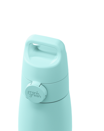 Close-up of a mint green grip handle lid with a built-in carry handle and a circular 'frank green' logo tab, closed on the matching bottle against a plain white background.