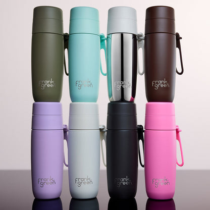 Eight Frank Green insulated water bottles in assorted colors, arranged in two rows of four on a reflective surface against a light gray background.